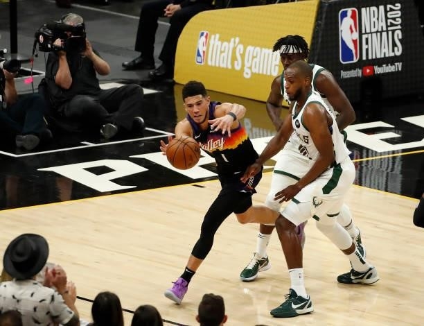 Devin Booker of the Phoenix Suns grabs the ball under pressure form Khris Middleton of the Milwaukee Bucks during the first half in Game One of the...