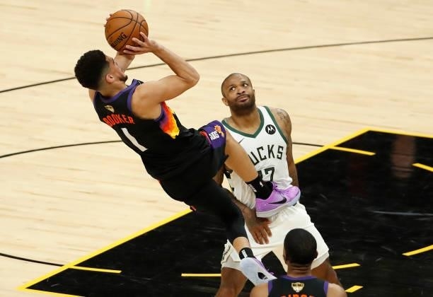Devin Booker of the Phoenix Suns is fouled by P.J. Tucker of the Milwaukee Bucks during the first half in Game One of the NBA Finals at Phoenix Suns...