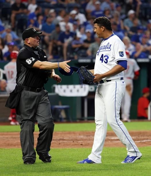Umpire Scott Barry inspects the hat and glove of pitcher Carlos Hernandez of the Kansas City Royals for substances during the game against the...