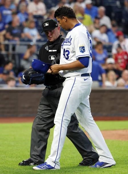 Umpire Scott Barry inspects the hat and glove of pitcher Carlos Hernandez of the Kansas City Royals for substances during the game against the...