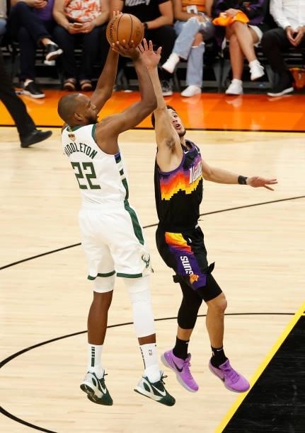 Khris Middleton of the Milwaukee Bucks shoots over Devin Booker of the Phoenix Suns during the first half in Game One of the NBA Finals at Phoenix...