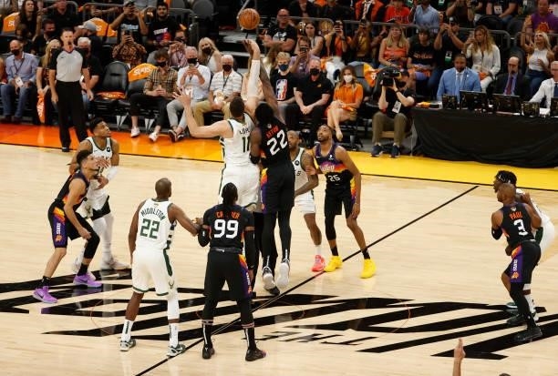 Brook Lopez of the Milwaukee Bucks and Deandre Ayton of the Phoenix Suns go up for the tip during the first quarter in Game One of the NBA Finals at...