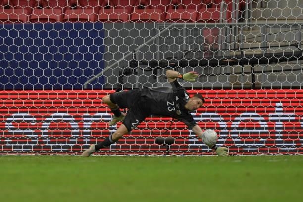 Emiliano Martinez goalkeeper of Argentina dives to save a penalty kick by Davinson Sanchez of Colombia in a shootout after a semi-final match of Copa...