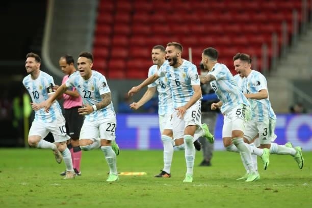 Lionel Messi, Lautaro Martinez and German Pezzella of Argentina celebrate with teammates winning a penalty shootout after a semi-final match of Copa...