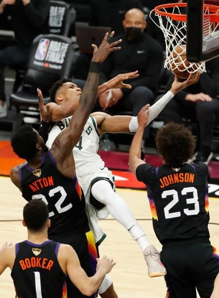 Giannis Antetokounmpo of the Milwaukee Bucks is pressured by Deandre Ayton of the Phoenix Suns during the second half in Game One of the NBA Finals...