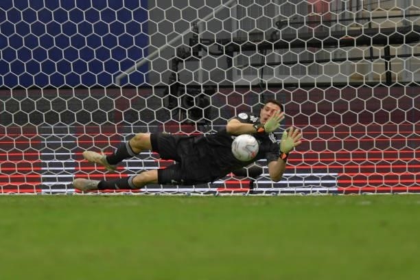 Emiliano Martinez goalkeeper of Argentina dives to save penalty kick by Edwin Cardona of Colombia in a shootout after a semi-final match of Copa...