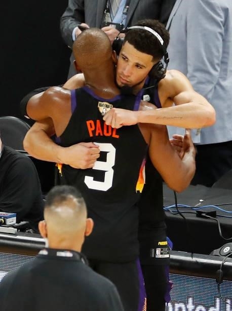 Devin Booker and Chris Paul of the Phoenix Suns hug after the team's win against the Milwaukee Bucks following Game One of the NBA Finals at Phoenix...
