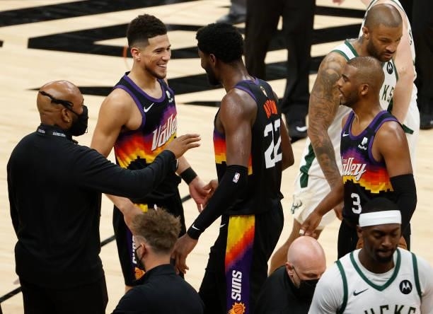 Devin Booker, Deandre Ayton and Chris Paul of the Phoenix Suns celebrate a win against the Milwaukee Bucks in Game One of the NBA Finals at Phoenix...