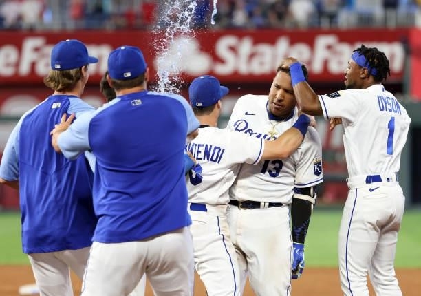 Teammates swarm Salvador Perez of the Kansas City Royals after Perez hit the game-winning walk-off single to defeat the Cincinnati Reds 7-6 and win...