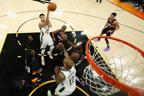 Giannis Antetokounmpo of the Milwaukee Bucks makes a leaping pass over Chris Paul of the Phoenix Suns during the second half of game one of the NBA...