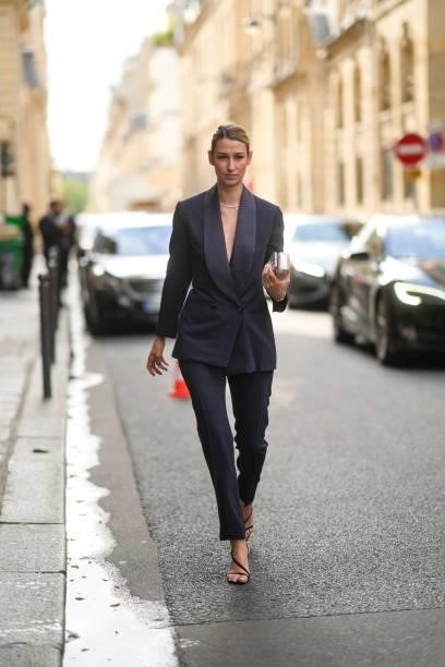 Guest wears a navy blue blazer jacket, matching navy blue suit pants, a silver rhinestones necklace, black suede strappy pumps heels sandals, a...