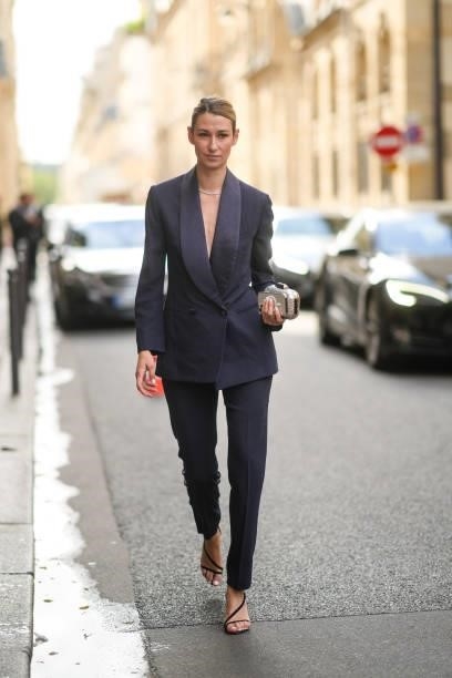 Guest wears a navy blue blazer jacket, matching navy blue suit pants, a silver rhinestones necklace, black suede strappy pumps heels sandals, a...