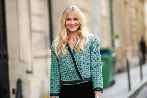 Guest wears a green and black checkered pattern with black and green embroidered sequins jacket, black flared pants, outside Armani, during Paris...
