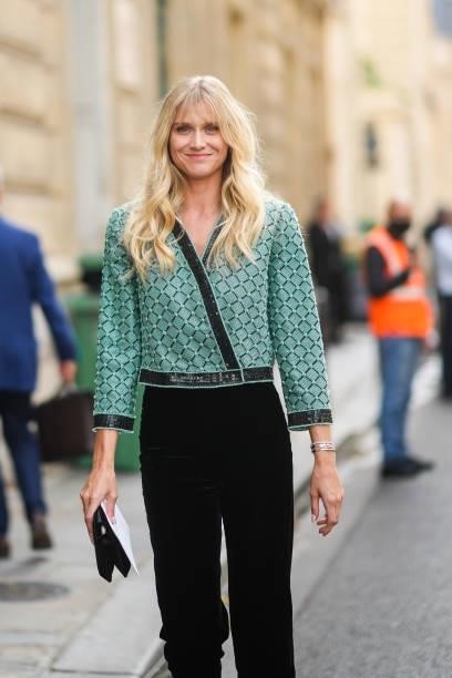 Guest wears a green and black checkered pattern with black and green embroidered sequins jacket, black flared pants, a silver bracelet, a silver...