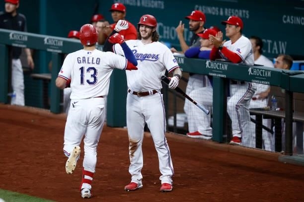 Joey Gallo of the Texas Rangers celebrates with Jonah Heim of the Texas Rangers after hitting a solo home run in the bottom of the fourth inning...