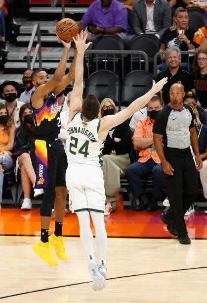 Mikal Bridges of the Phoenix Suns attempts a three-point shot over Pat Connaughton of the Milwaukee Bucks game one of the NBA Finals at Phoenix Suns...