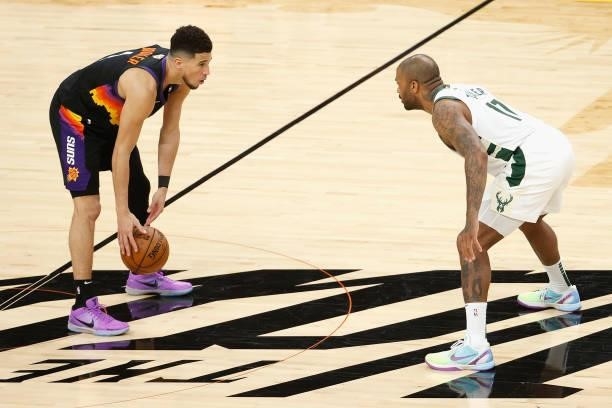 Devin Booker of the Phoenix Suns controls the ball against P.J. Tucker of the Milwaukee Bucks during game one of the NBA Finals at Phoenix Suns Arena...