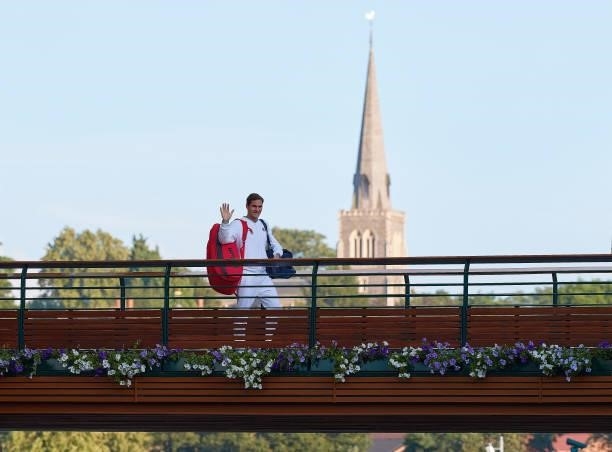 Roger Federer of Switzerland waves as he walks across the players bridge after losing his men's Singles Quarter Final match against Hubert Hurkacz of...