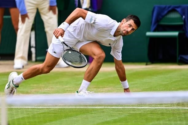 Novak Djokovic of Serbia slips over during his match against Marton Fucsovics of Hungary in the quarter finals of the gentlemen's singles during Day...