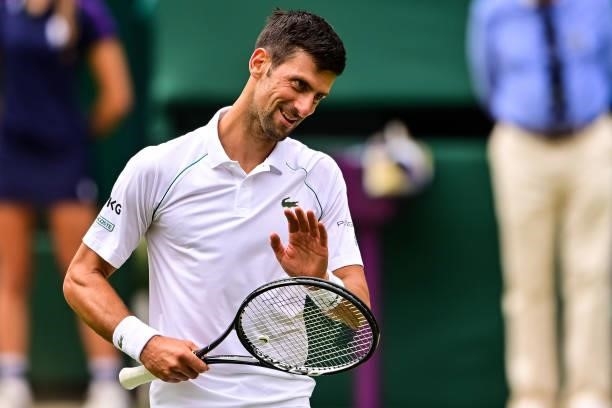 Novak Djokovic of Serbia smiles at his team during his match against Marton Fucsovics of Hungary in the quarter finals of the gentlemen's singles...