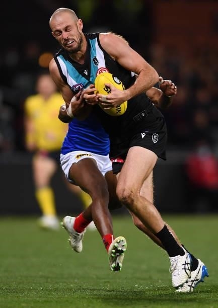 Jarrod Lienert of Port Adelaide tackled by Kysaiah Pickett of the Demons during the round 17 AFL match between Port Adelaide Power and Melbourne...