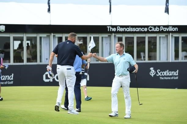 Matthew Southgate of England and Jamie Donaldson of Wales finish their rounds on the 18th green during Day One of the abrdn Scottish Open at The...