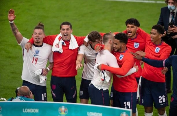 Luke Shaw and Reece James greet each other as Kalvin Phillips, Conor Coady, John Stones, Tyrone Mings and Jude Bellingham celebrate after the UEFA...