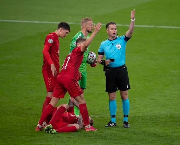 Simon Kjær of Denmark lies on the floor injured as referee Danny Makkelie calls for the physio during the UEFA Euro 2020 Championship Semi-final...