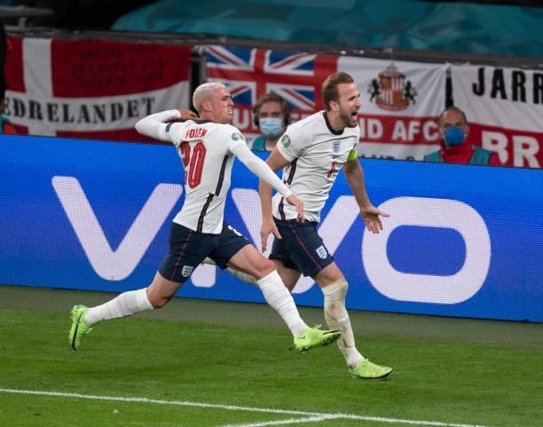 Harry Kane celebrates with team mate Phil Foden after he scores England's second goal during the UEFA Euro 2020 Championship Semi-final match between...