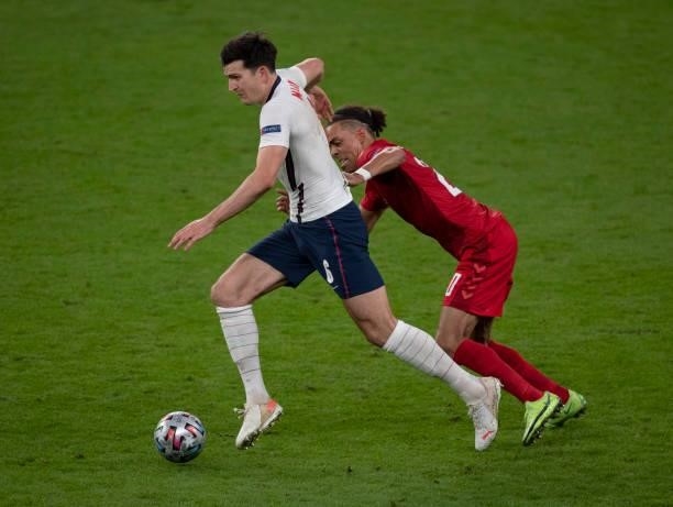 Harry Maguire of England and Yussuf Poulsen of Denmark in action during the UEFA Euro 2020 Championship Semi-final match between England and Denmark...