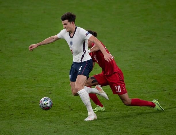 Harry Maguire of England and Yussuf Poulsen of Denmark in action during the UEFA Euro 2020 Championship Semi-final match between England and Denmark...