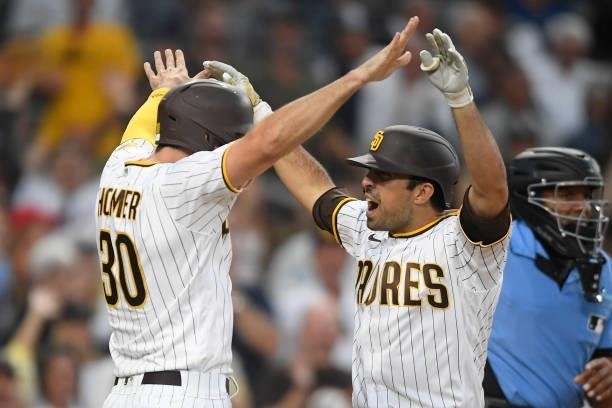 Daniel Camerena of the San Diego Padres, right, is congratulated by Eric Hosmer after hitting a grand slam home run during the fourth inning of a...