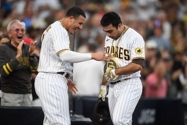 Manny Machado of the San Diego Padres puts the swagg chain onto Daniel Camerena after he hit a grand slam home run during the fourth inning of a...