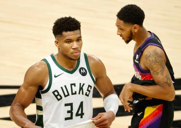Giannis Antetokounmpo of the Milwaukee Bucks walks off the court past Cameron Payne of the Phoenix Suns following game two of the NBA Finals at...