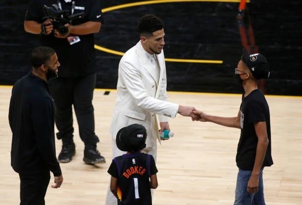 Devin Booker of the Phoenix Suns greets fans following a 118-108 victory over the Milwaukee Bucks in Game Two of the NBA finals at Phoenix Suns Arena...