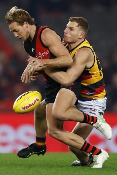 Rory Laird of the Crows tackles Darcy Parish of the Bombers during the round 17 AFL match between Essendon Bombers and Adelaide Crows at Marvel...