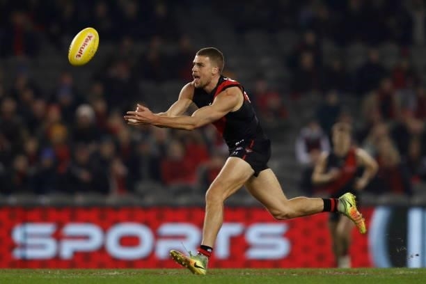 Tom Cutler of the Bombers handballs during the round 17 AFL match between Essendon Bombers and Adelaide Crows at Marvel Stadium on July 09, 2021 in...