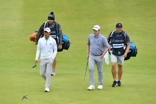 Collin Morikawa of The United States and Robert MacIntyre of Scotland walk on the 18th hole during Day Two of the abrdn Scottish Open at The...