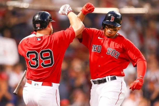 Rafael Devers reacts with Christian Arroyo of the Boston Red Sox after hitting a solo home run in the third inning of a game against the Philadelphia...