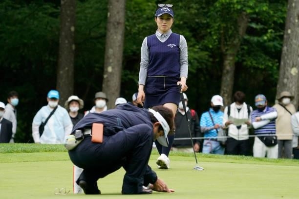 Yuna Nishimura of Japan waits while JLPGA rules official to rebuild the cup after her second shot hitting the cup directly on the 6th hole during the...