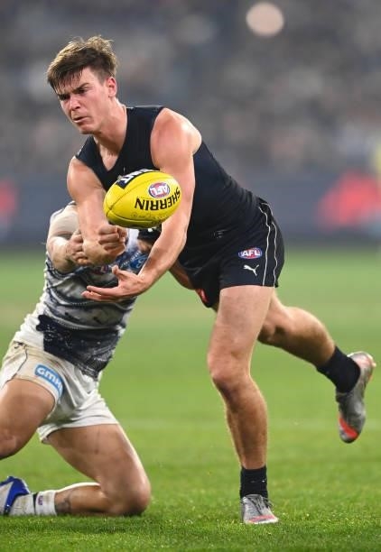 Paddy Dow of the Blues handballs whilst being tackled by Brandan Parfitt of the Cats during the round 17 AFL match between Carlton Blues and Geelong...