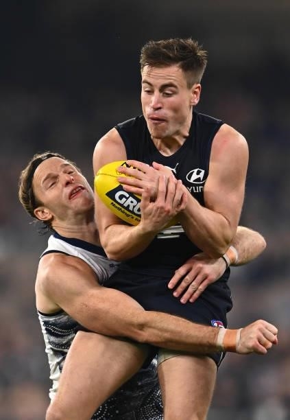Matthew Owies of the Blues marks infront of Lachie Henderson of the Cats during the round 17 AFL match between Carlton Blues and Geelong Cats at...