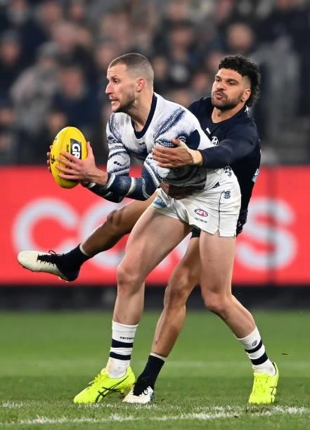 Sam Menegola of the Cats is tackled by Sam Petrevski-Seton of the Blues during the round 17 AFL match between Carlton Blues and Geelong Cats at...