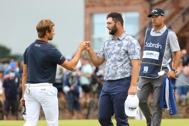 Jon Rahm of Spain fists bumps with Thomas Detry of Belgium on the 18th green during Day Three of the abrdn Scottish Open at The Renaissance Club on...