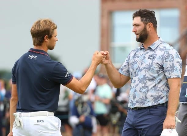 Jon Rahm of Spain fists bumps with Thomas Detry of Belgium on the 18th green during Day Three of the abrdn Scottish Open at The Renaissance Club on...