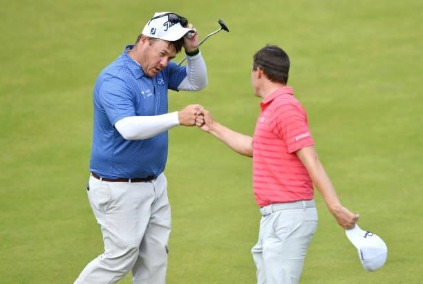George Coetzee of South Africa and Matthew Fitzpatrick of England fist bump on the 18th green during Day Three of the abrdn Scottish Open at The...