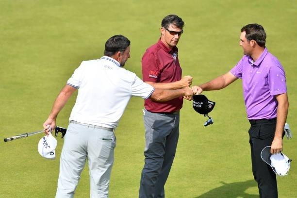 Richard Bland of England, Padraig Harrington of Ireland and Scottie Scheffler of the United States interact on the 18th green during Day Three of the...