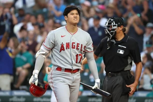 Shohei Ohtani of the Los Angeles Angels reacts after striking out while swinging to end the top of the fifth inning against the Seattle Mariners at...