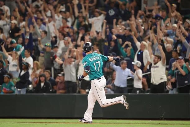 Mitch Haniger of the Seattle Mariners points to the dugout while lapping the bases after hitting a grand slam to take a 7-3 lead against the Los...