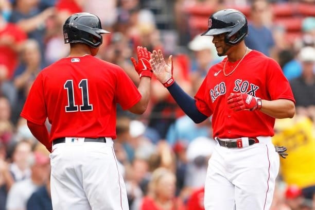 Xander Bogaerts of the Boston Red Sox celebrates with Rafael Devers after hitting a home run against the Philadelphia Phillies during the second...